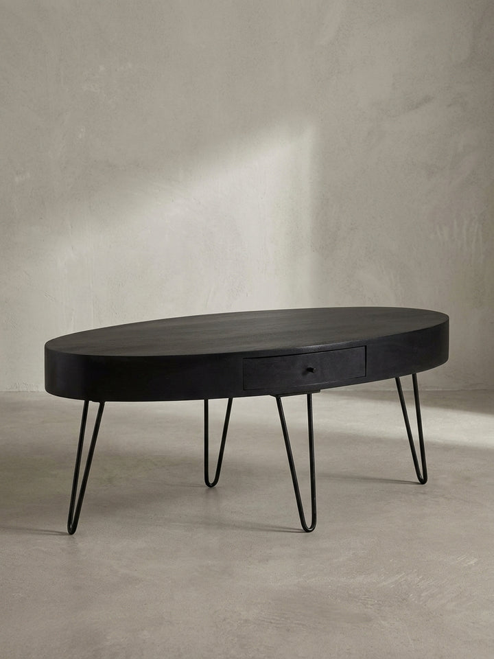 Nahaufnahme des dezenten schwarzen Schubladengriffs am Couchtisch, ein Detail, das Funktionalität und minimalistisches Design vereint._