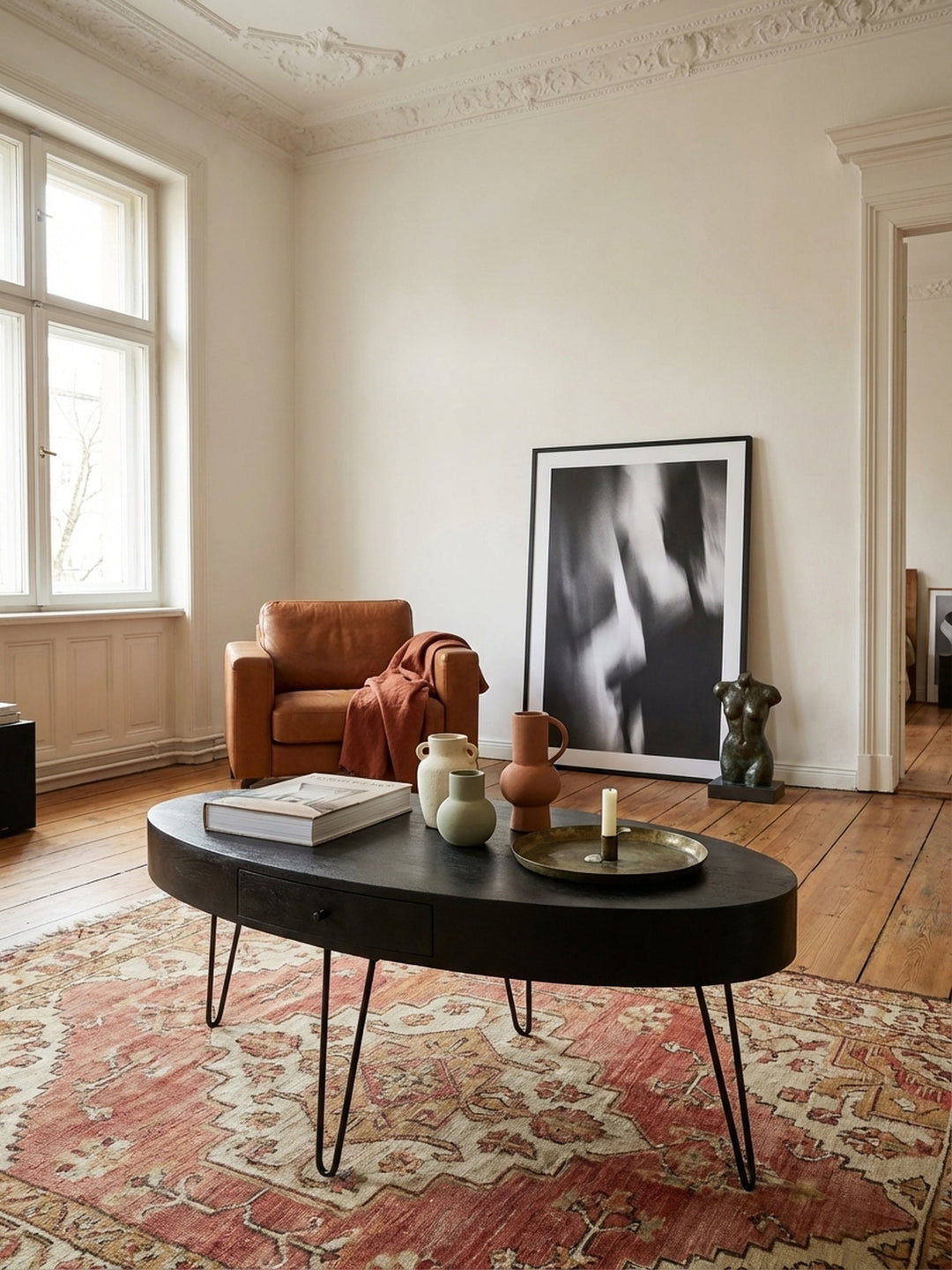 Detailaufnahme der markanten Maserung des schwarz lackierten Mango-Massivholzes, die die handwerkliche Qualität des Kaffeetisches unterstreicht._