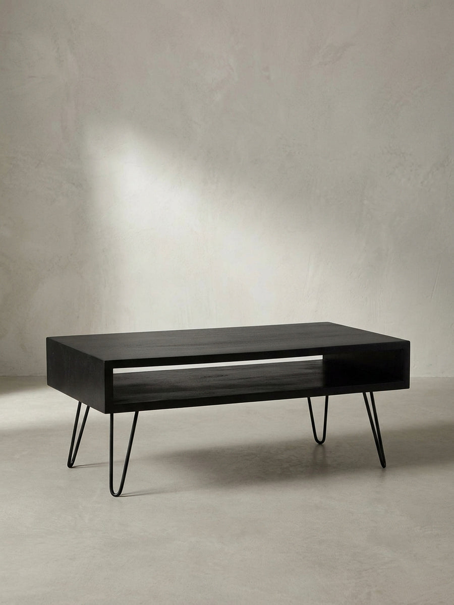 Gesamtüberblick über den rechteckigen Couchtisch im Industrial-Design, gefertigt aus massivem Mangoholz mit schwarzen Eisenbeinen._