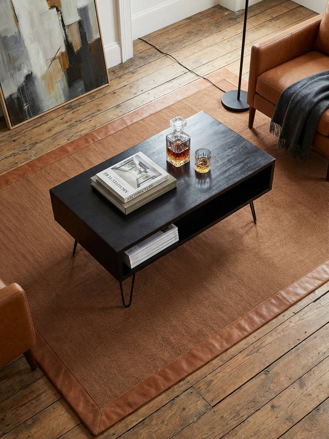 Rechteckiger Sofatisch aus massivem Holz von oben gesehen, arrangiert mit Büchern und Tasse auf einem beigen Teppich vor einer modernen Couch._