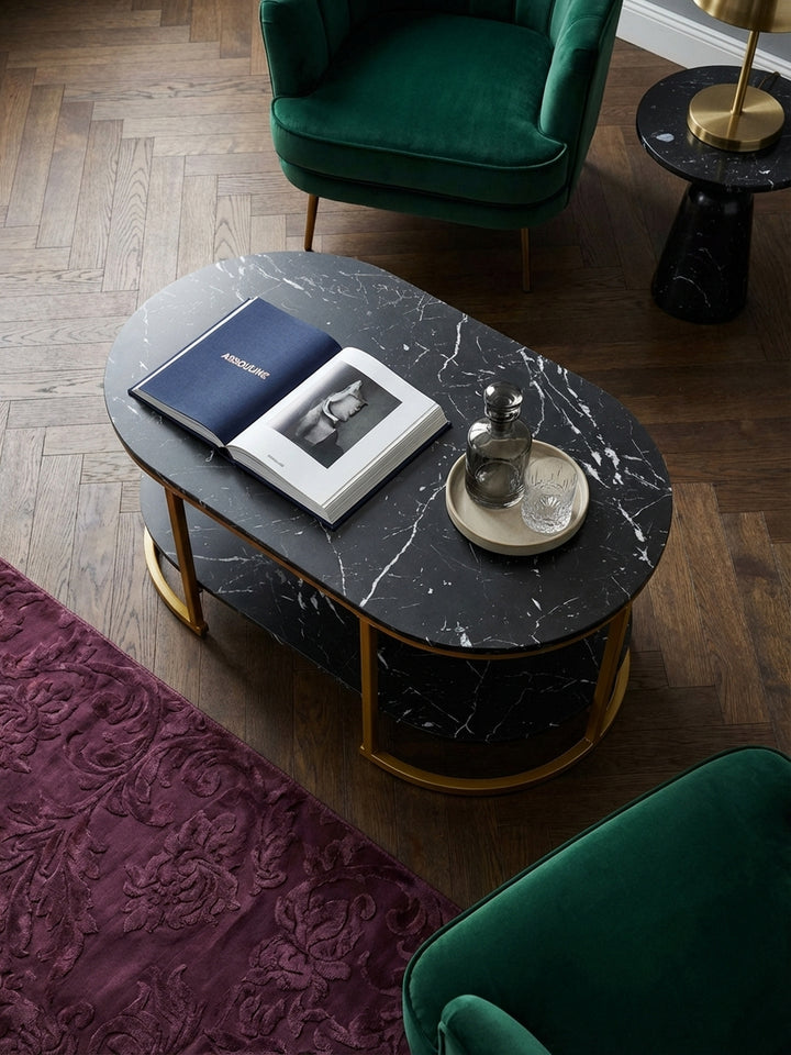 Blick von oben auf den Design-Couchtisch mit zwei Ablagen, arrangiert auf einem seidenen Pflaumen-Teppich neben einem smaragdgrünen Samtsofa in einem stilvollen Altbau._