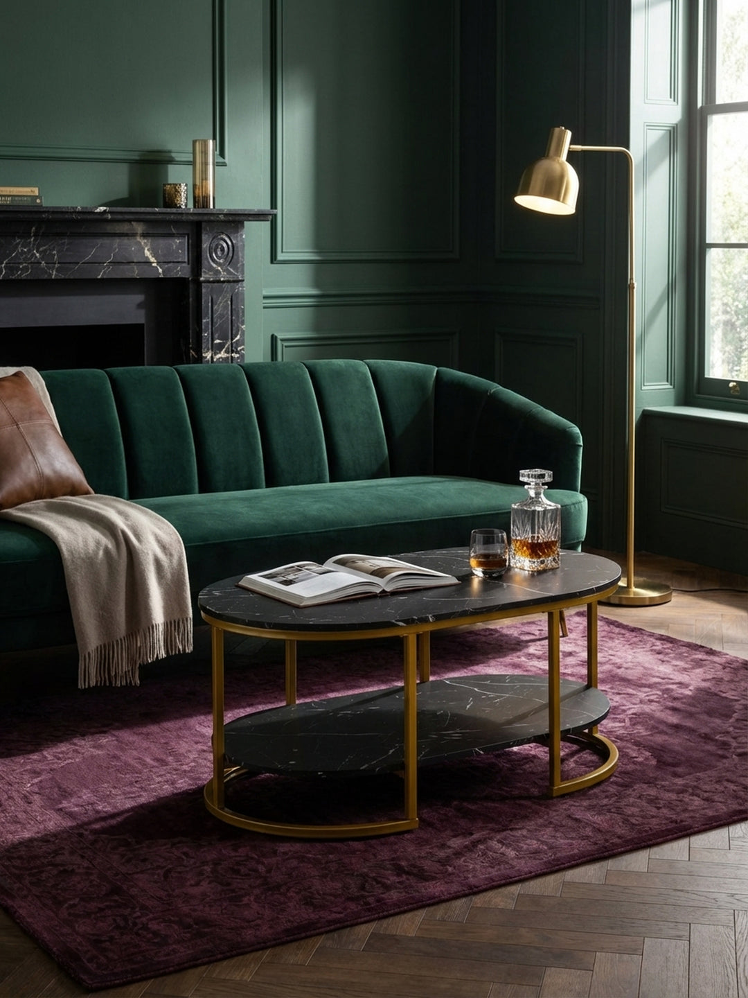 Der ovale Kaffeetisch in Schwarz und Gold kombiniert mit einem dunkelgrünen Samtsessel und einer Messing-Stehlampe, eine perfekte Einrichtungsidee für ein edles Wohnzimmer._