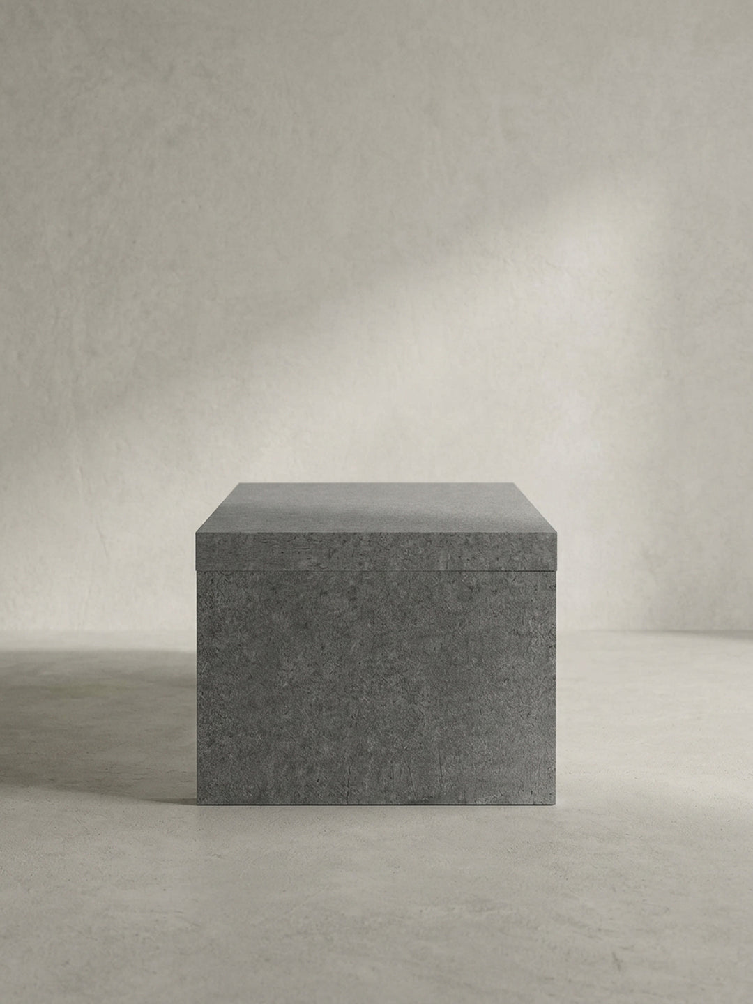 Vollständige Silhouette des puristischen Couchtisches in Grau, der durch sein kompromissloses Design als skulpturales Statement-Piece im Raum wirkt_