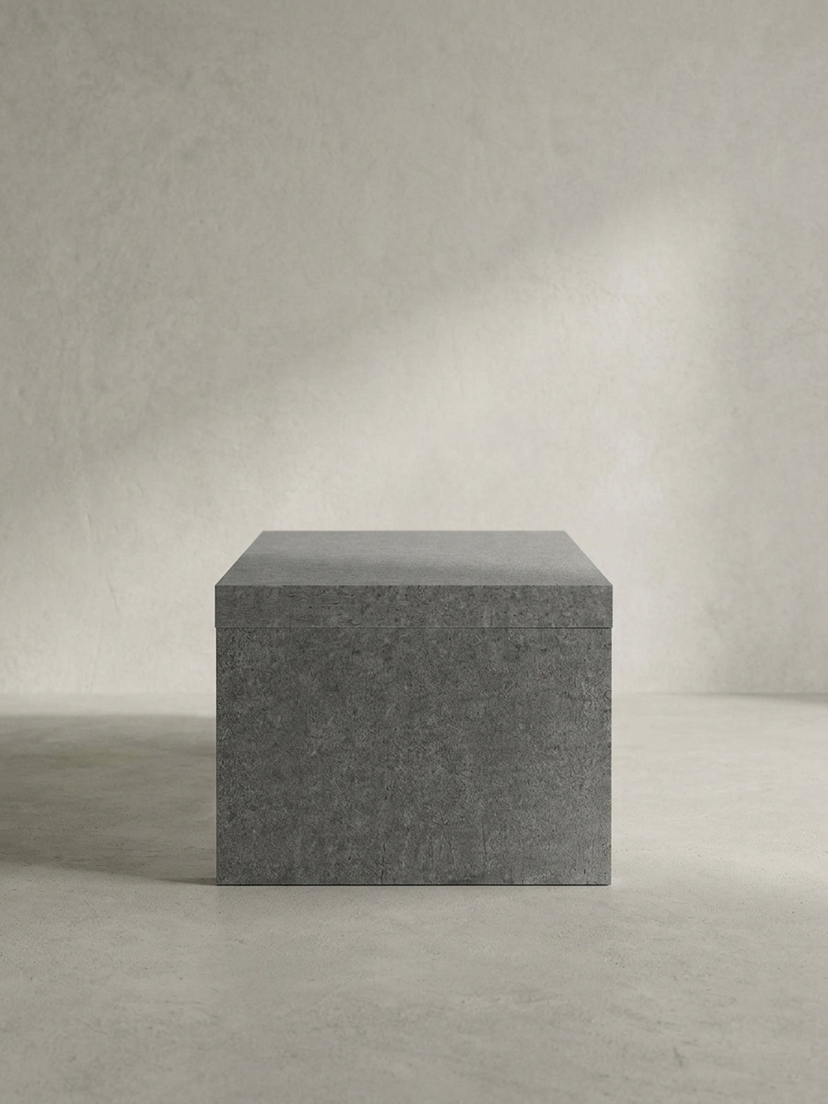 Vollständige Silhouette des puristischen Couchtisches in Grau, der durch sein kompromissloses Design als skulpturales Statement-Piece im Raum wirkt