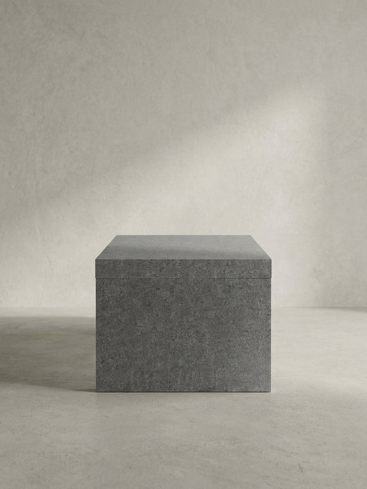Vollständige Silhouette des puristischen Couchtisches in Grau, der durch sein kompromissloses Design als skulpturales Statement-Piece im Raum wirkt_