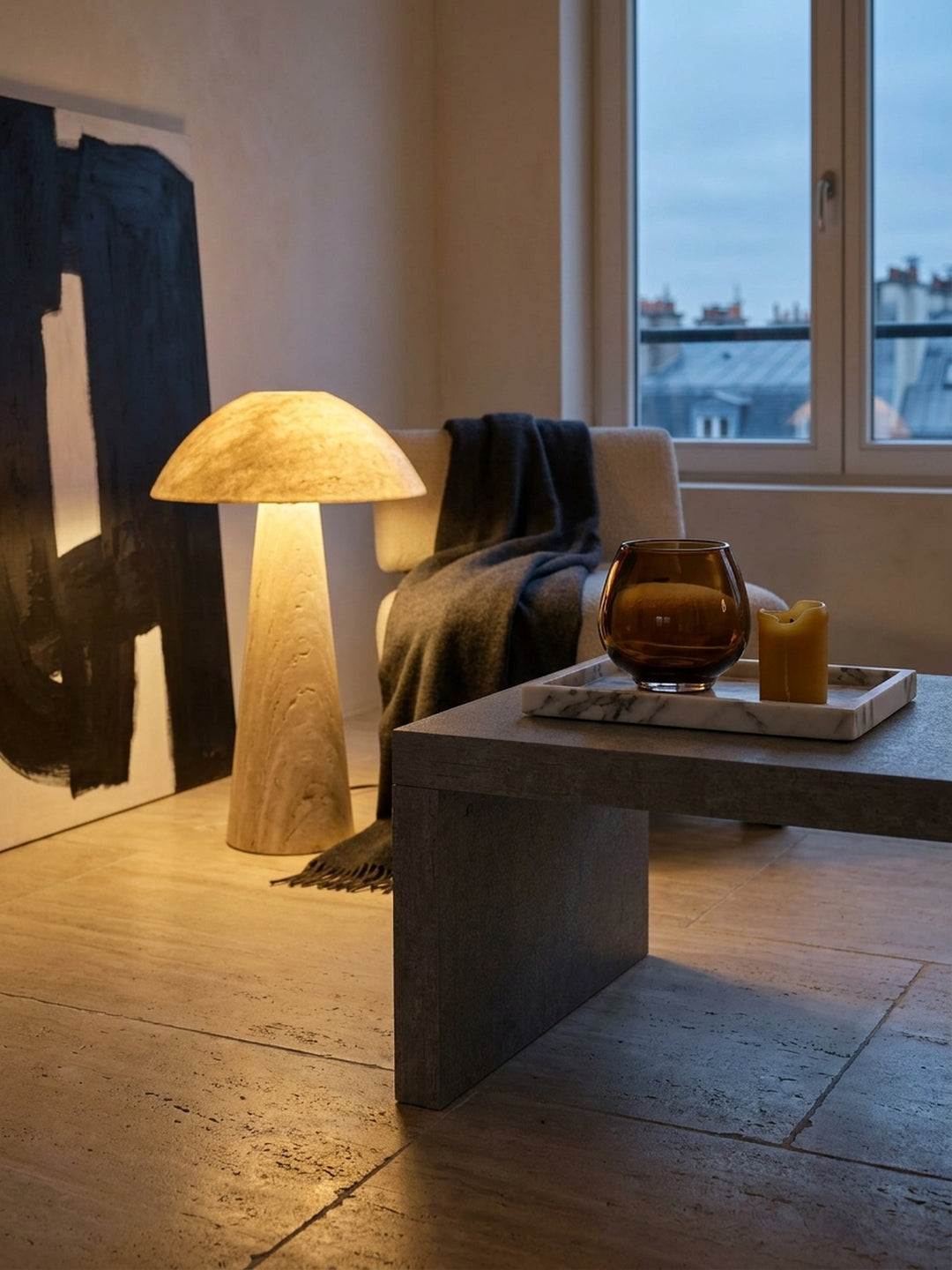 Ein aufgeschlagenes Architekturbuch liegt entspannt auf dem grauen Kaffeetisch neben einer Bernsteich neben einer Bernsteinglas-Vase im luxuriösen, minimalistischen Ambiente_