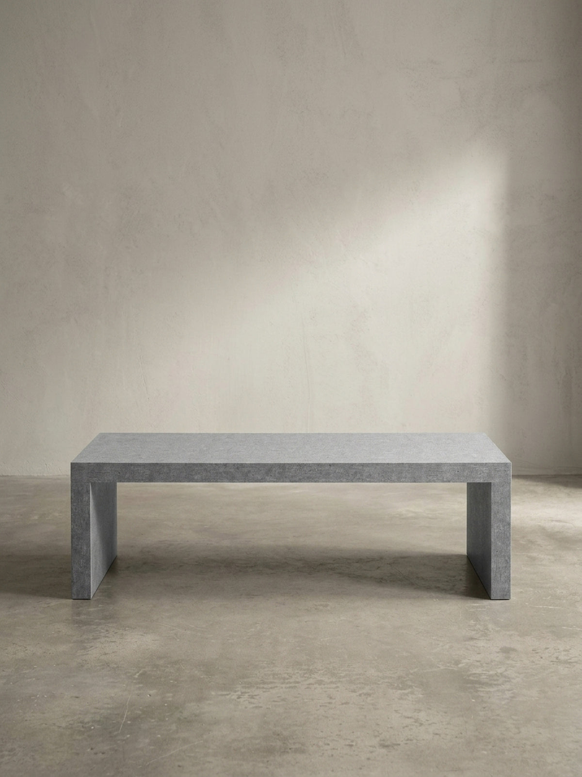 Freistehender Loungetisch aus MDF in kühlem Grau aus leicht seitlicher Perspektive, die die markante 5 cm dicke Materialstärke der Tischplatte betont_