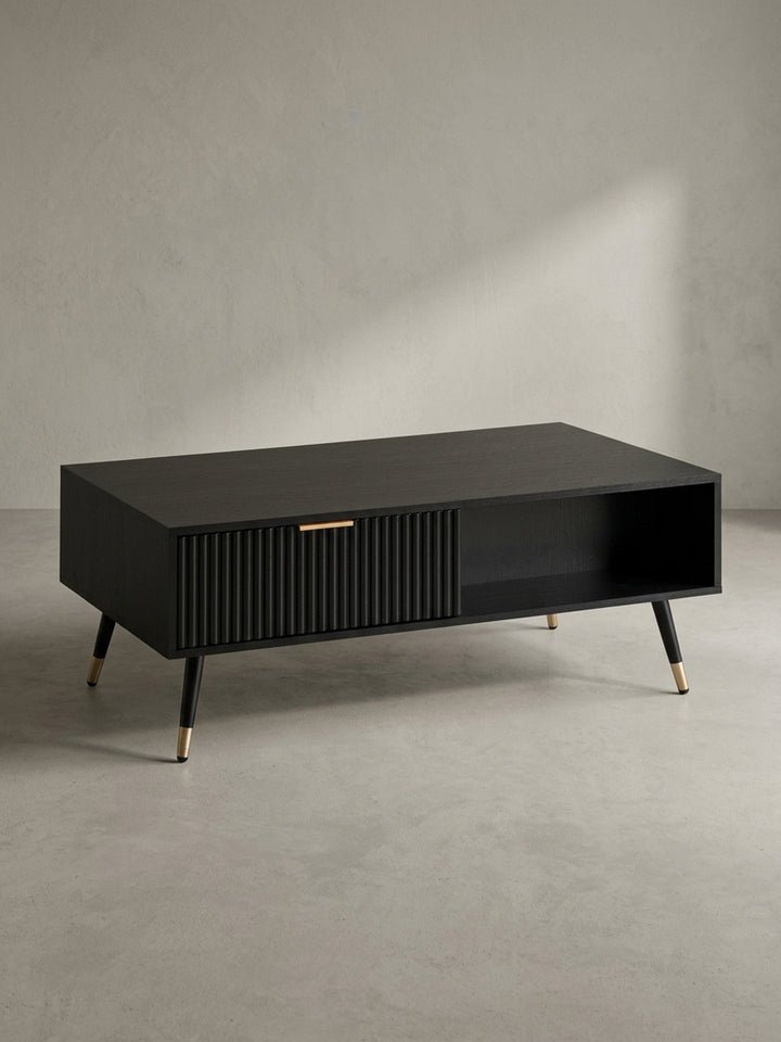 Moderner Couchtisch in Schwarz mit Eiche-Optik und goldfarbenen Details, freigestellt in der Frontalansicht, die die klare Linienführung betont._
