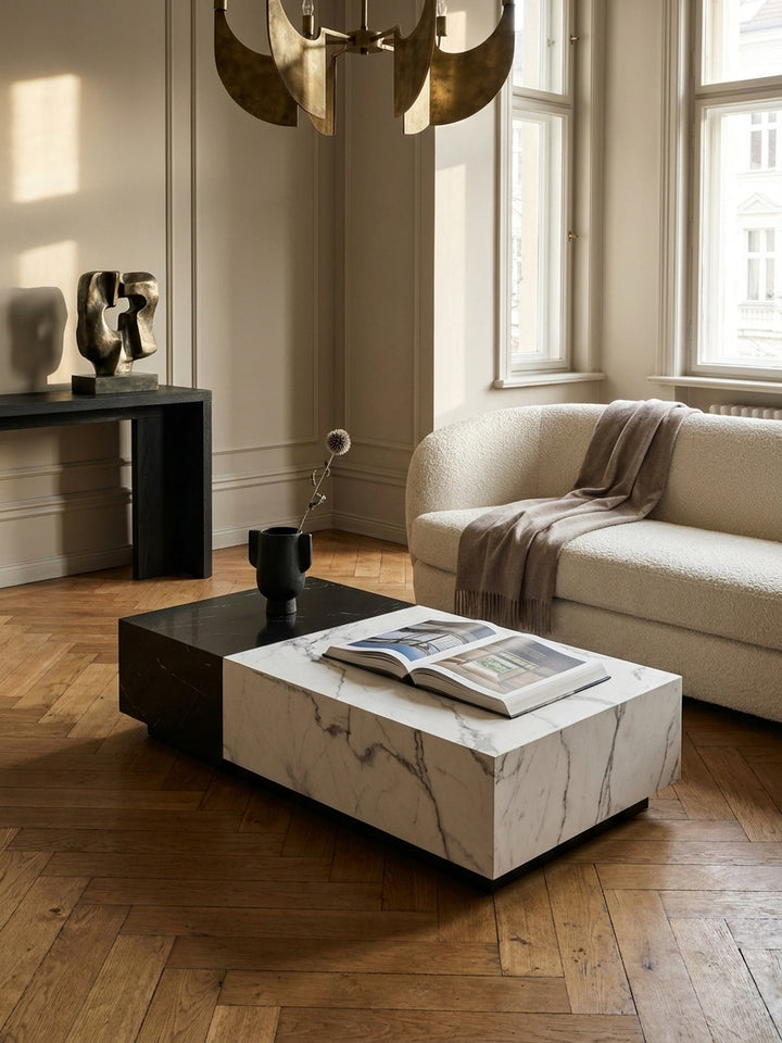 Der niedrige Wohnzimmertisch in Marmor-Optik harmoniert perfekt mit einem cremefarbenen Ecksofa und einem Beistelltisch aus dunklem Holz._