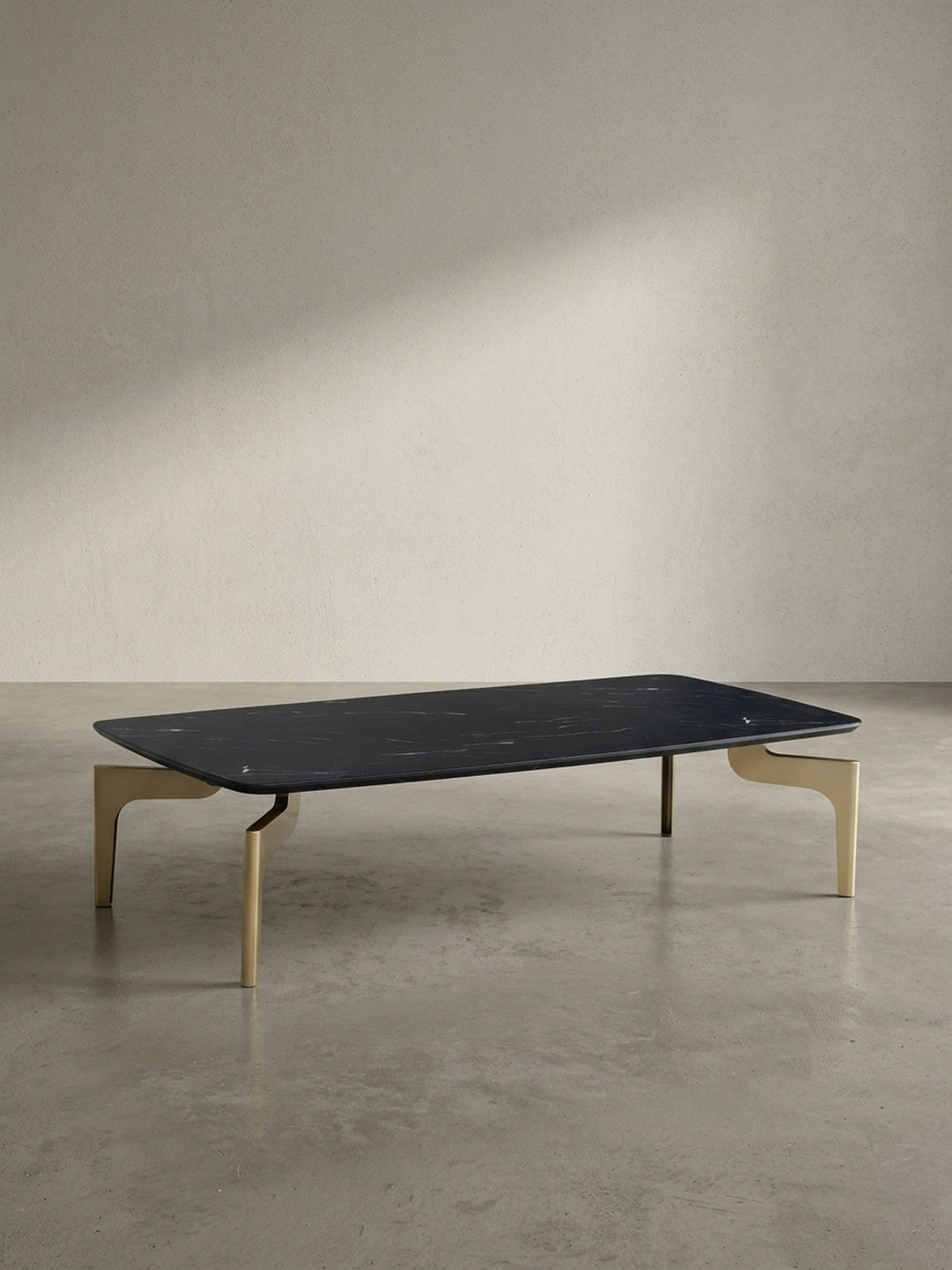 Flacher Couchtisch mit 120 cm Länge in schwarzer Marmor-Optik und pulverbeschichteten goldenen Beinen freigestellt vor neutralem weißem Hintergrund_