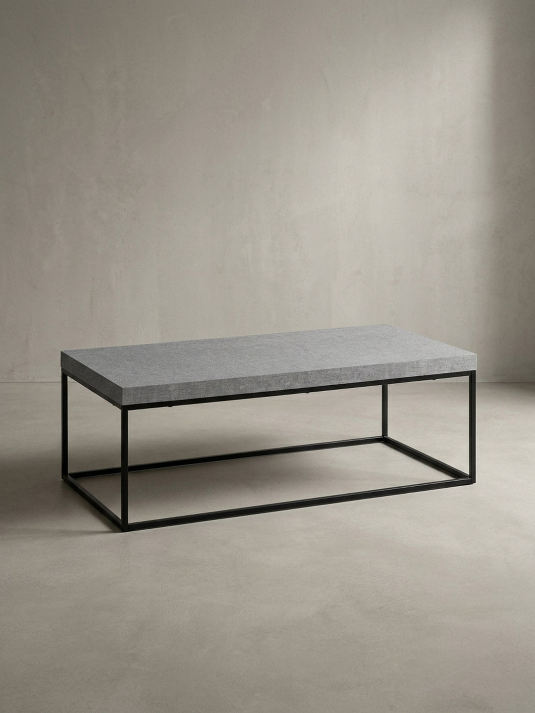 Design-Wohnzimmertisch in Grau und Schwarz aus der 3/4-Perspektive, die das minimalistische Zusammenspiel von Platte und Gestell zeigt._