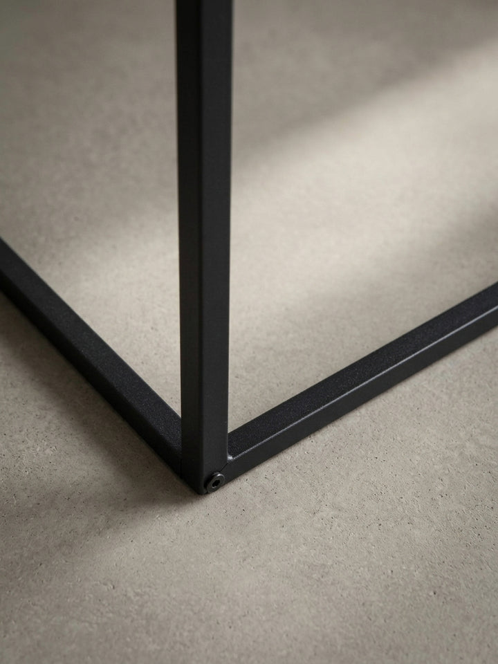 Nahaufnahme der Kante des Sofatisches, die die präzise Folierung in Stein-Optik und den sauberen Übergang zum schwarzen Metallgestell detailliert abbildet._