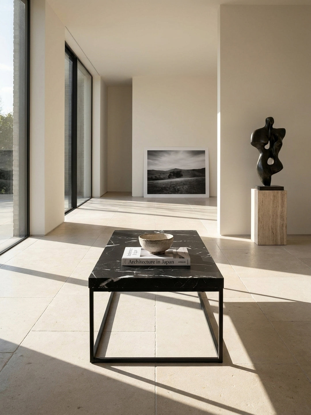 Schwarzer Couchtisch in Marmor-Optik 120x60x38 cm als eleganter Mittelpunkt in einem minimalistischen Wohnzimmer mit hellen Kalksteinböden und großen architektonischen Fenstern_