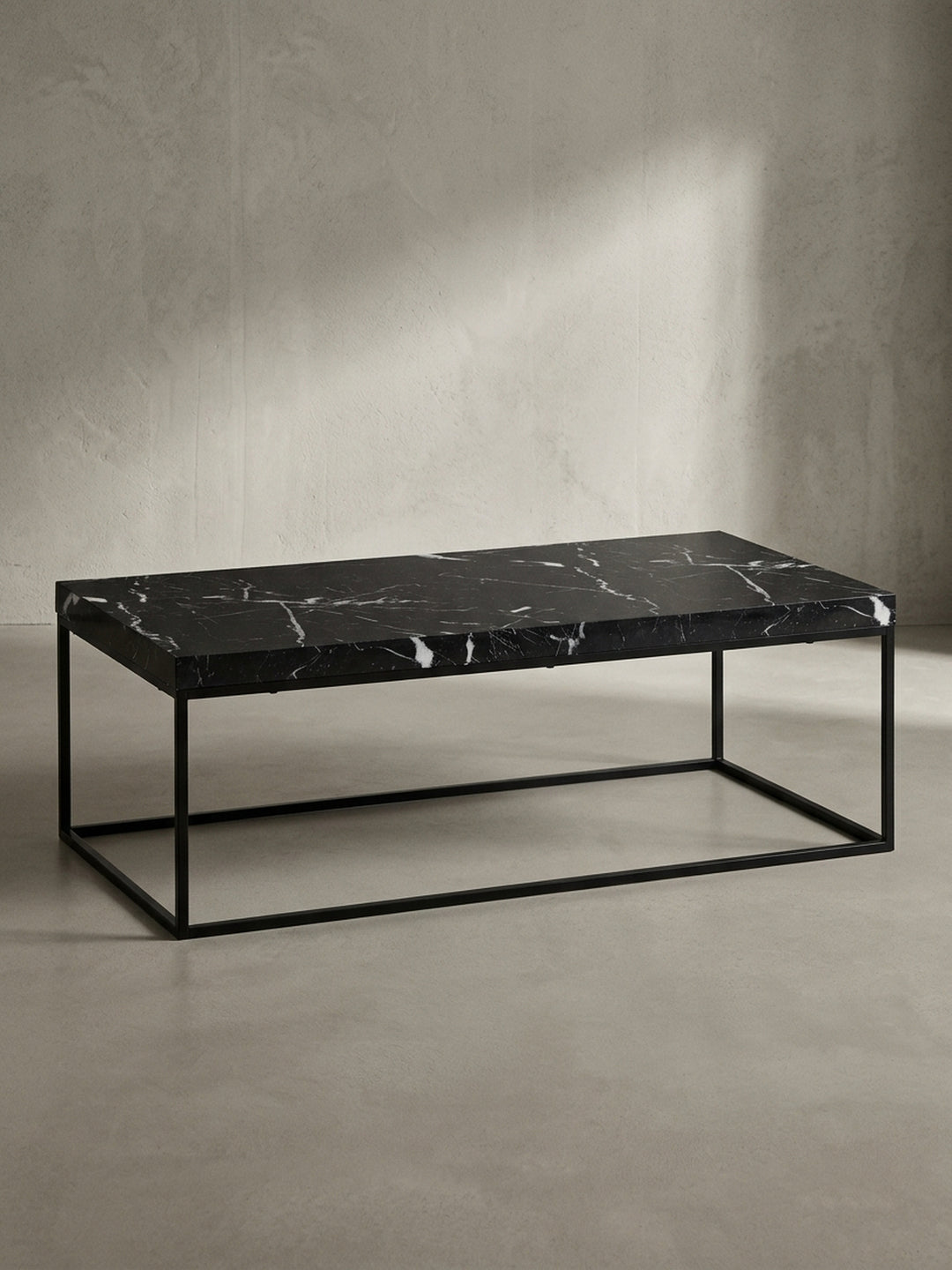 Vorderansicht des rechteckigen Couchtischs 120x60 cm mit dunkler Marmor-Optik und geradlinigem schwarzen Eisen-Gestell freigestellt vor einem neutralen Fotostudio-Hintergrund_
