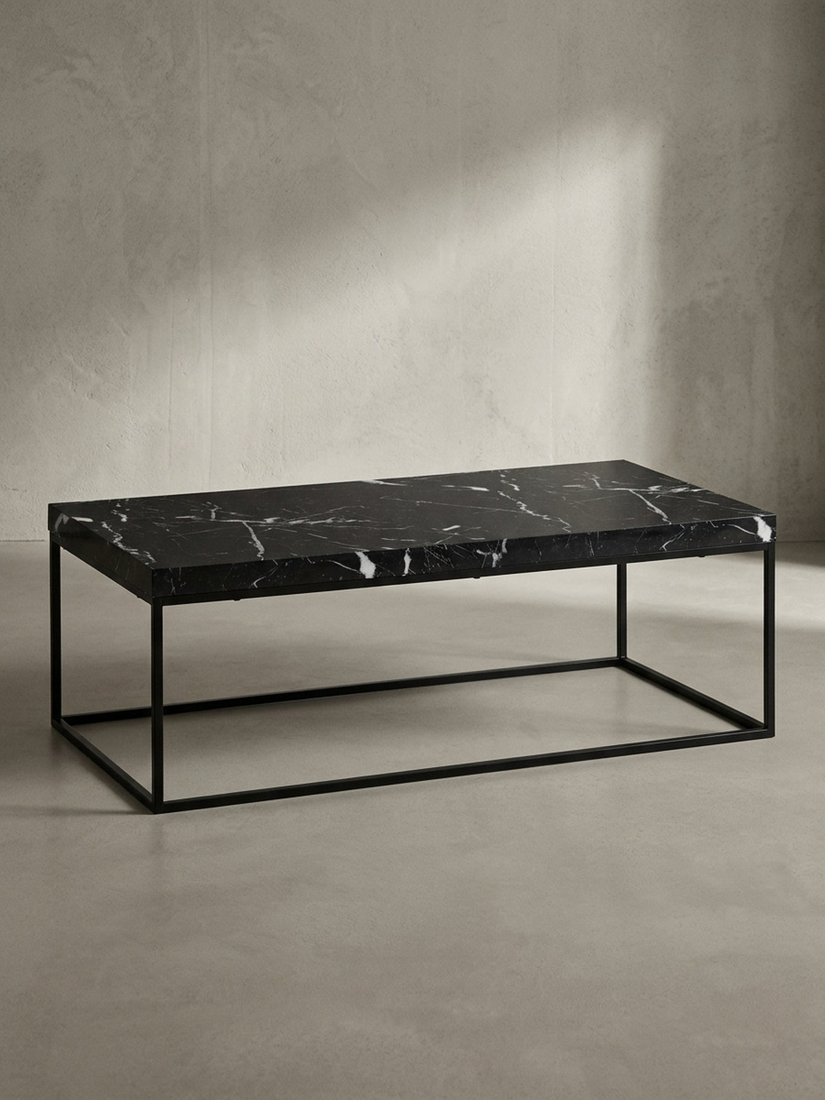 Vorderansicht des rechteckigen Couchtischs 120x60 cm mit dunkler Marmor-Optik und geradlinigem schwarzen Eisen-Gestell freigestellt vor einem neutralen Fotostudio-Hintergrund_