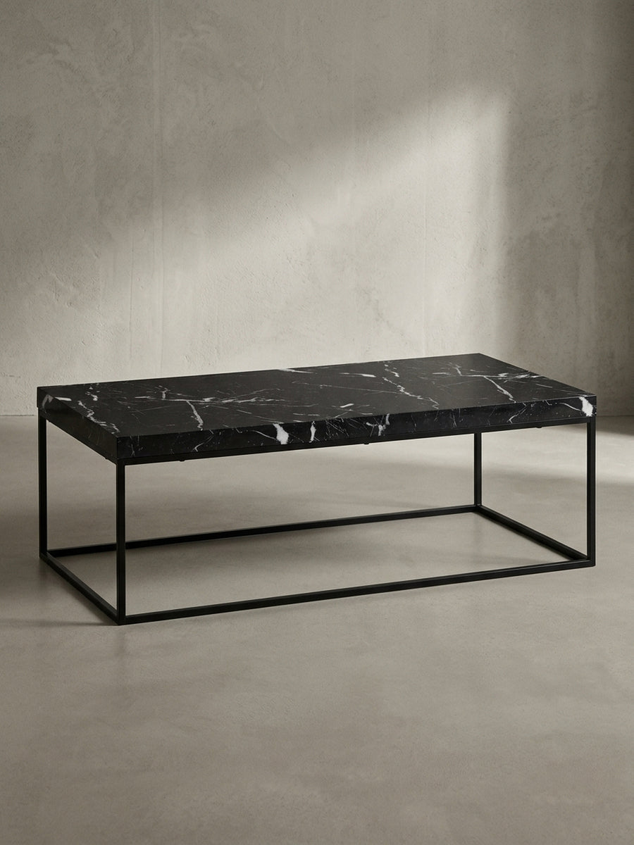 Vorderansicht des rechteckigen Couchtischs 120x60 cm mit dunkler Marmor-Optik und geradlinigem schwarzen Eisen-Gestell freigestellt vor einem neutralen Fotostudio-Hintergrund_