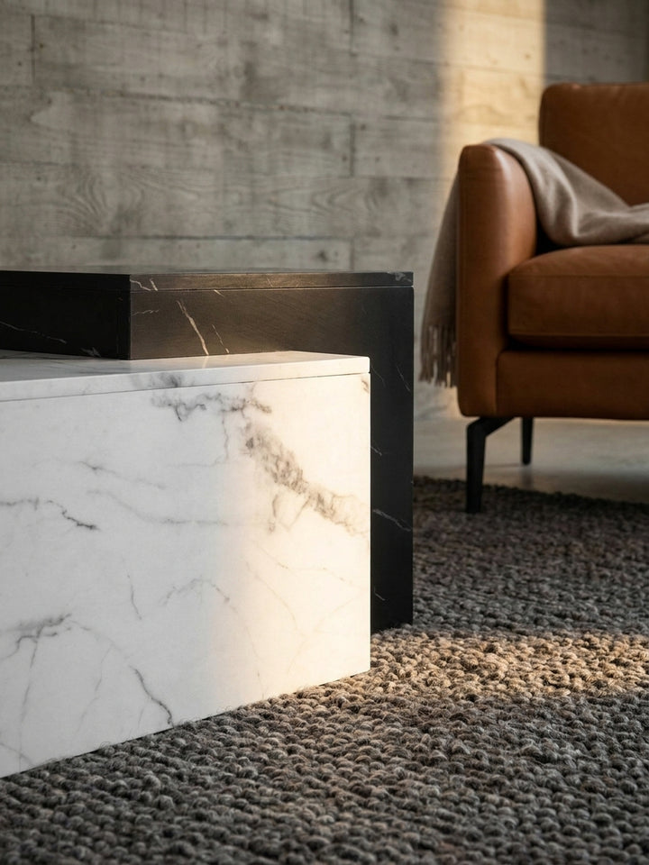 Detailaufnahme der glänzenden Oberfläche des Couchtisches, die die feine, graue Maserung der weißen Marmor-Optik und die glatte Lackierung zeigt._