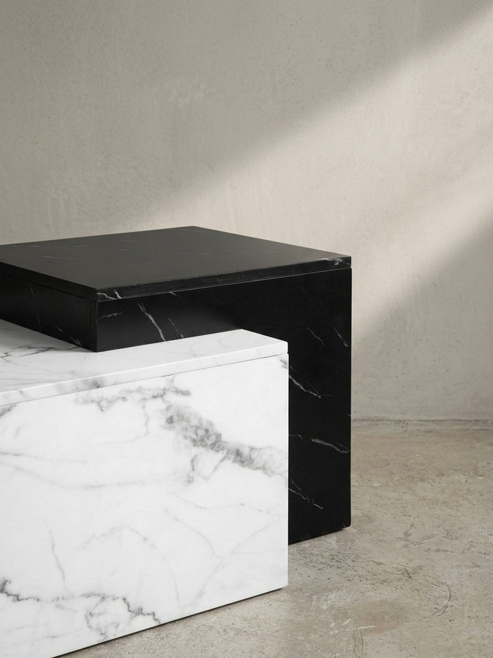 Schräge Ansicht des Loungetisches, die das Zusammenspiel von schwarzer und weißer Marmor-Optik und die geometrische Silhouette des Designs betont._