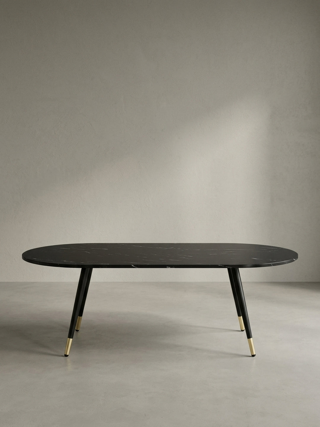 Seitenansicht des flachen Kaffeetisches in Schwarz mit eleganter Silhouette und einer zwei Zentimeter dicken folierten MDF-Tischplatte._