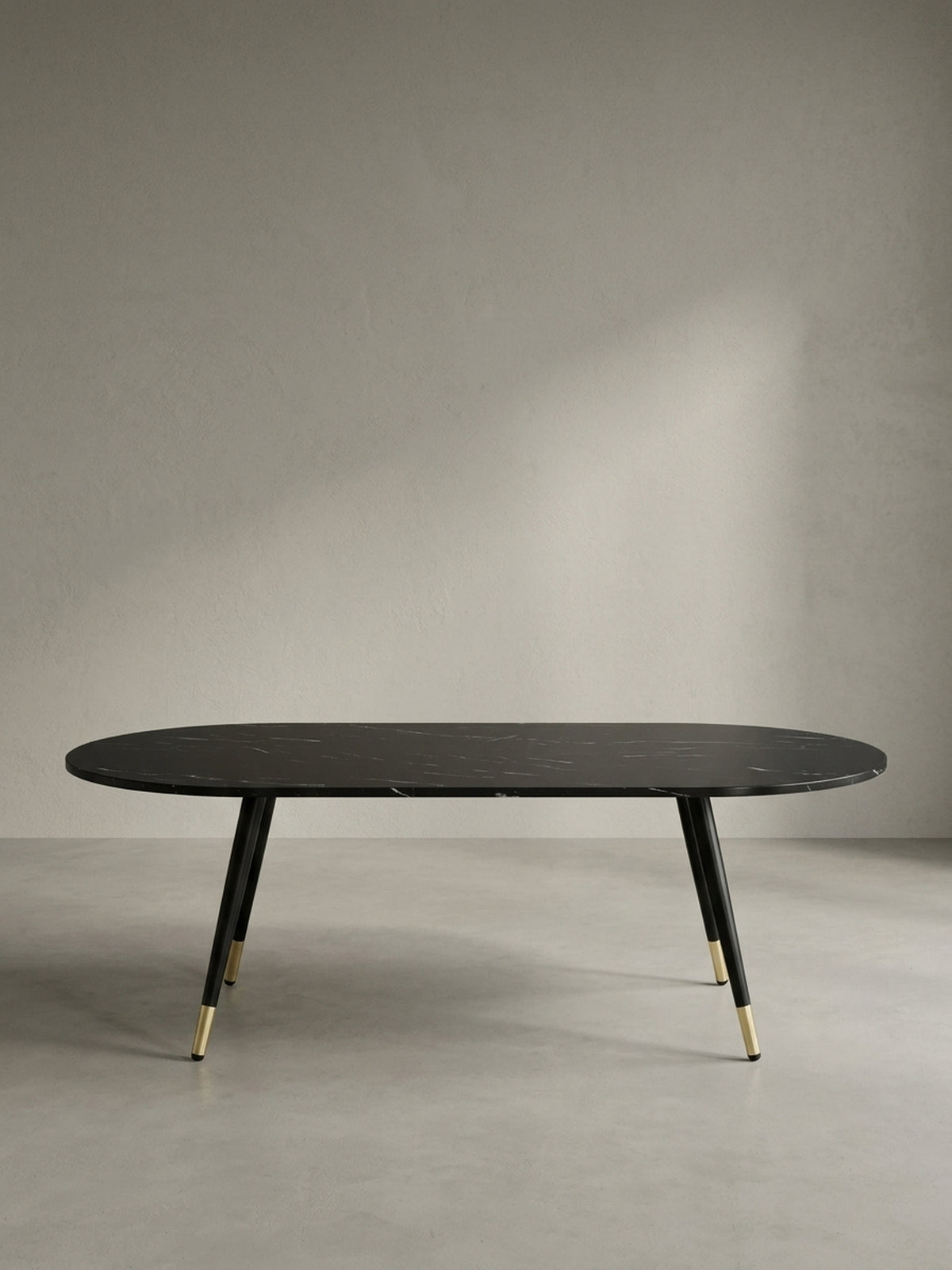 Seitenansicht des flachen Kaffeetisches in Schwarz mit eleganter Silhouette und einer zwei Zentimeter dicken folierten MDF-Tischplatte.