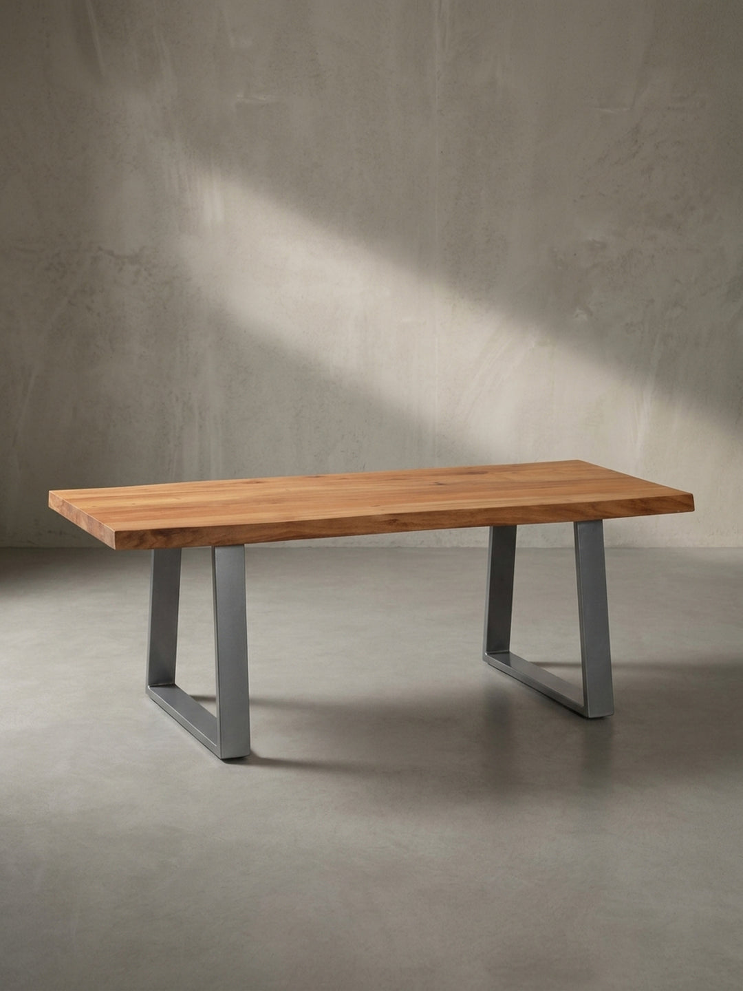 Rechteckiger Wohnzimmertisch im Industrial Design mit asymmetrischer Baumkante leicht schräg von der Seite betrachtet im Fotostudio._