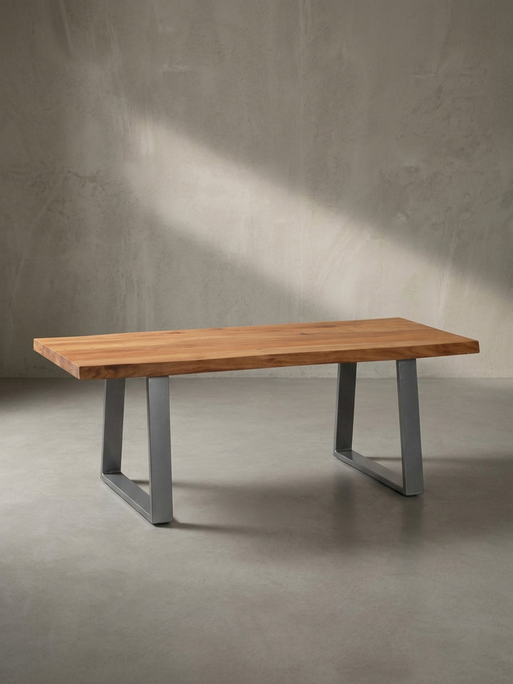 Rechteckiger Wohnzimmertisch im Industrial Design mit asymmetrischer Baumkante leicht schräg von der Seite betrachtet im Fotostudio._
