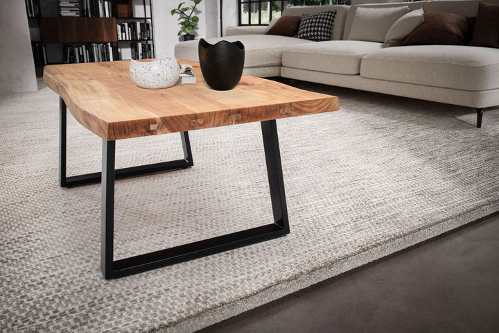 Couchtisch aus Akazie Massivholz mit Metall-Trapezbeinen und Baumkante im Design-Stil