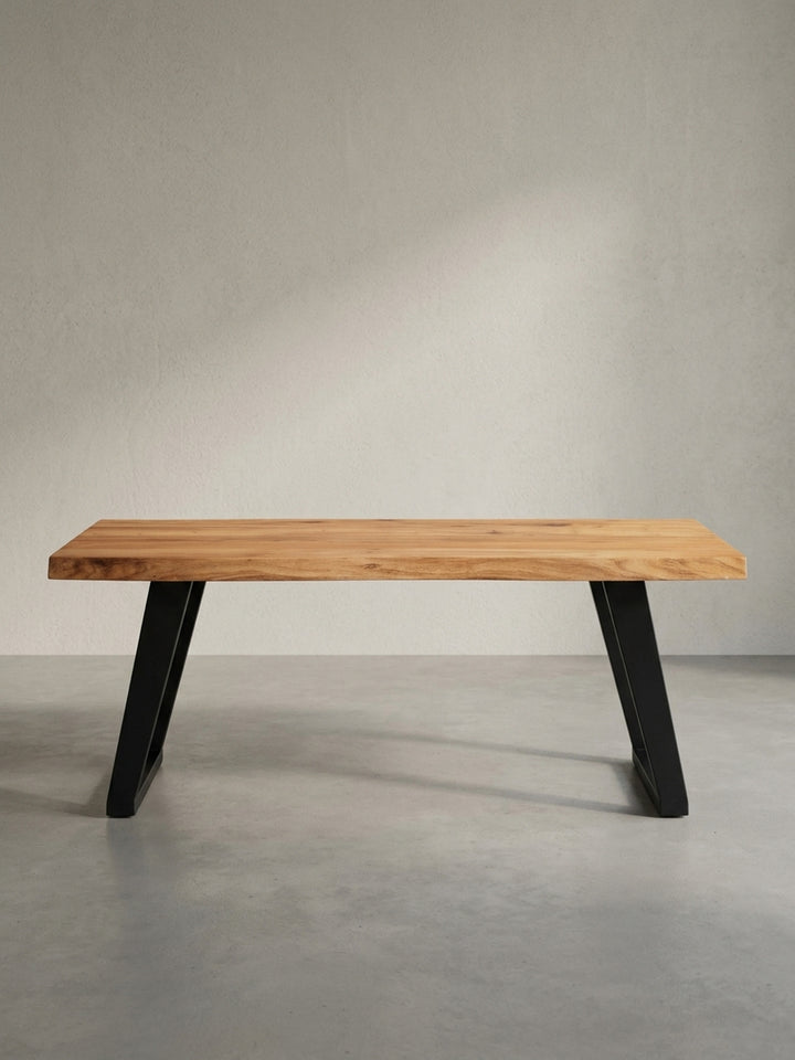 Schräge 3/4-Ansicht des Sofatisches zeigt die dicke 4cm-Tischplatte aus Akazienholz und das robuste, pulverbeschichtete Eisengestell in Schwarz._