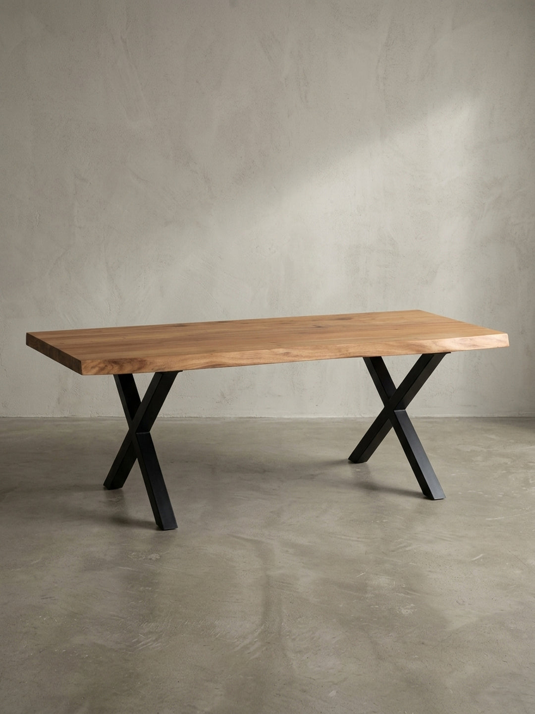 Frontansicht des Design-Couchtischs aus Akazie mit markanten, schwarzen X-förmigen Metallbeinen auf weißem Hintergrund._