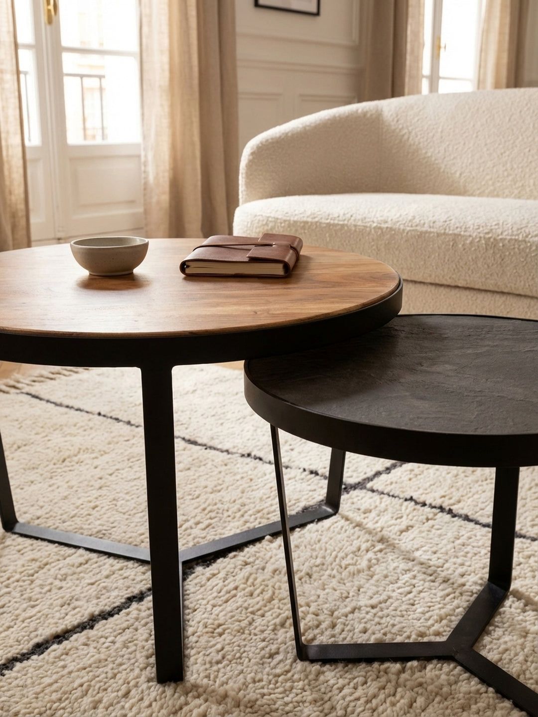 Detailaufnahme der markanten Holzmaserung eines runden Couchtischs aus massivem Akazienholz, eingefasst in einen mattschwarzen Metallrahmen._