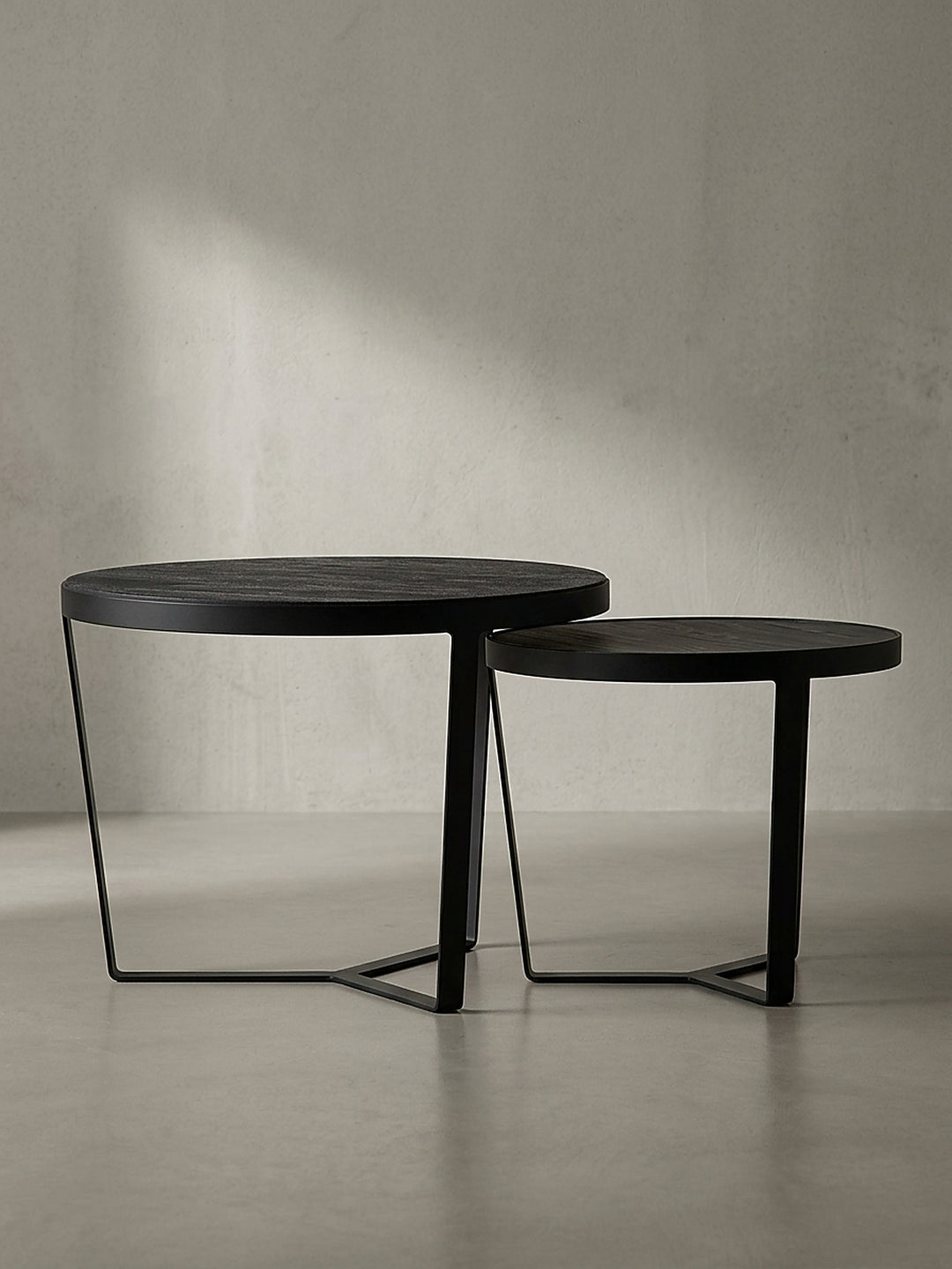 Schwarzes Couchtisch-Set aus Massivholz und schiefergrauem Holzwerkstoff repräsentiert eine zeitlose Formensprache für ein modernes Wohnzimmer_