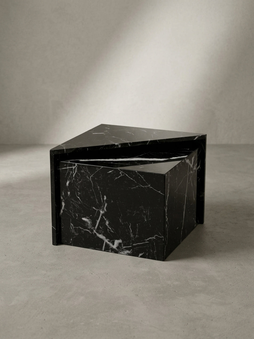 Gesamtübersicht des modernen Couchtisches in edlem Schwarz mit feinem Marmor-Effekt, präsentiert als alleinstehendes geometrisches Objekt vor einer weißen Wand_