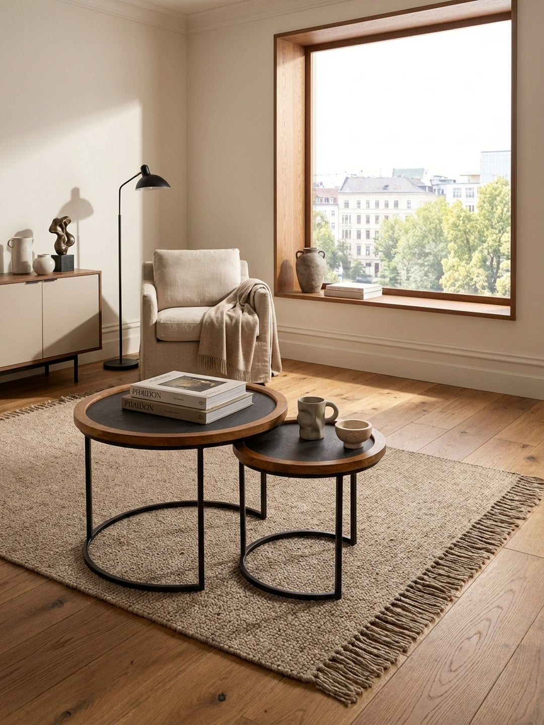 Runder Satztisch aus Mangoholz und Metall als zentrales Element in einem hellen Wohnzimmer mit einem beigen Wollteppich und einem modernen Sofa._