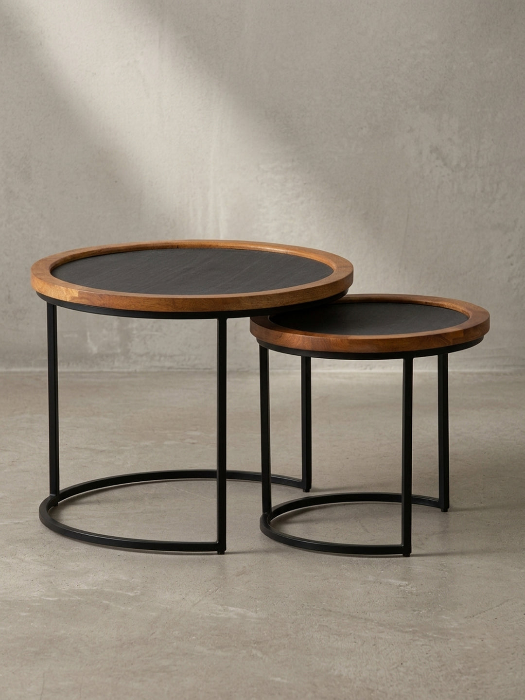 Vorderansicht des zweiteiligen Couchtisch-Sets mit Mangoholzrand und schwarzem Metallgestell, isoliert auf weißem Hintergrund._