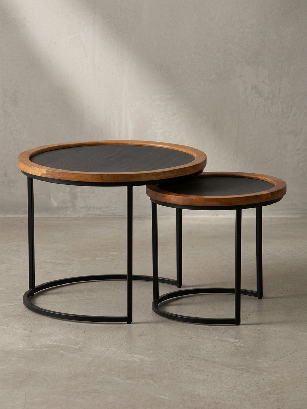 Vorderansicht des zweiteiligen Couchtisch-Sets mit Mangoholzrand und schwarzem Metallgestell, isoliert auf weißem Hintergrund._