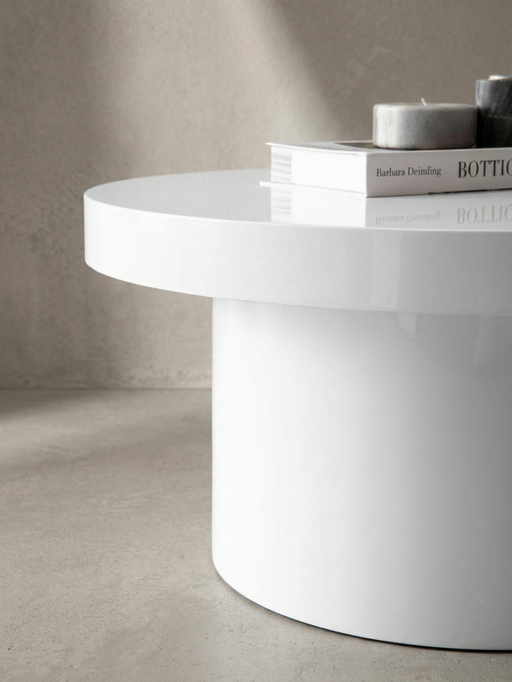 Detailaufnahme der Kante der Tischplatte des weißen Kaffeetischs, die die präzise Verarbeitung und die Stärke des Materials in Hochglanz-Optik verdeutlicht._