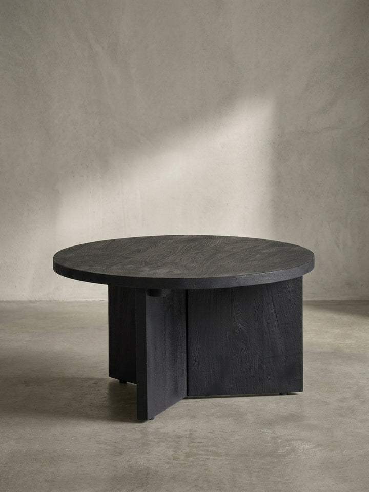 Gesamtbild des runden, schwarzen Couchtisches aus Mango-Massivholz, der natürliche Holzmaserung mit modernem, geometrischem Design verbindet._