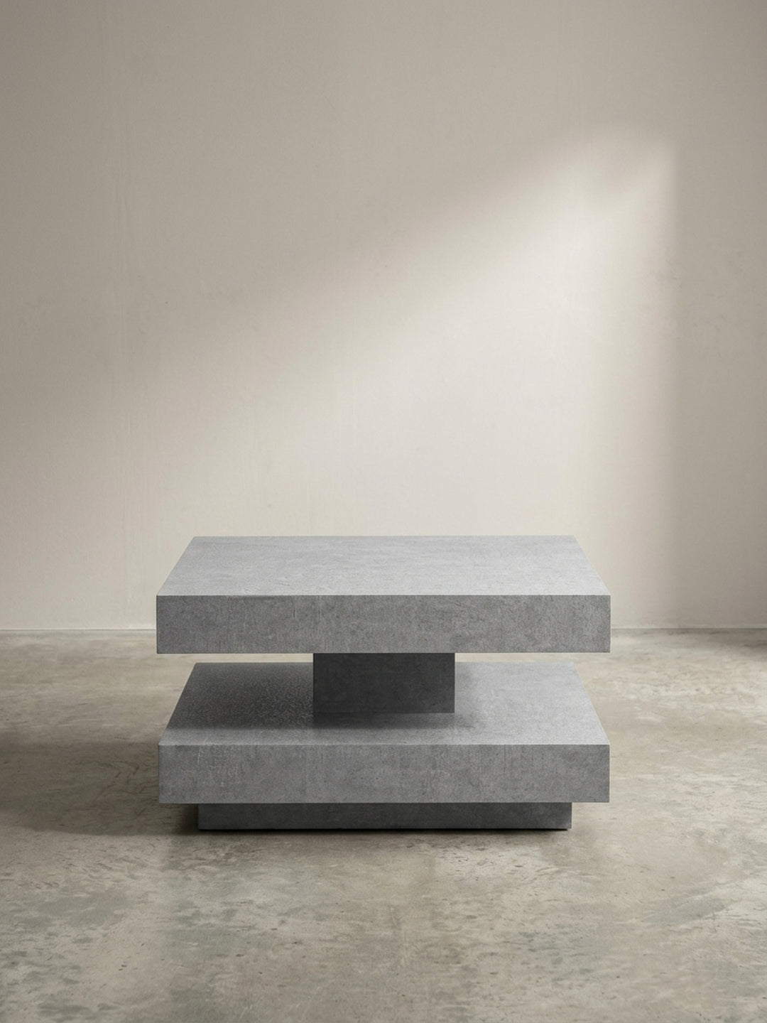 Schräge 3/4-Ansicht des modernen Sofatisches in Grau, die Tiefe und das geometrische Design der doppelten Ablagefläche betont._