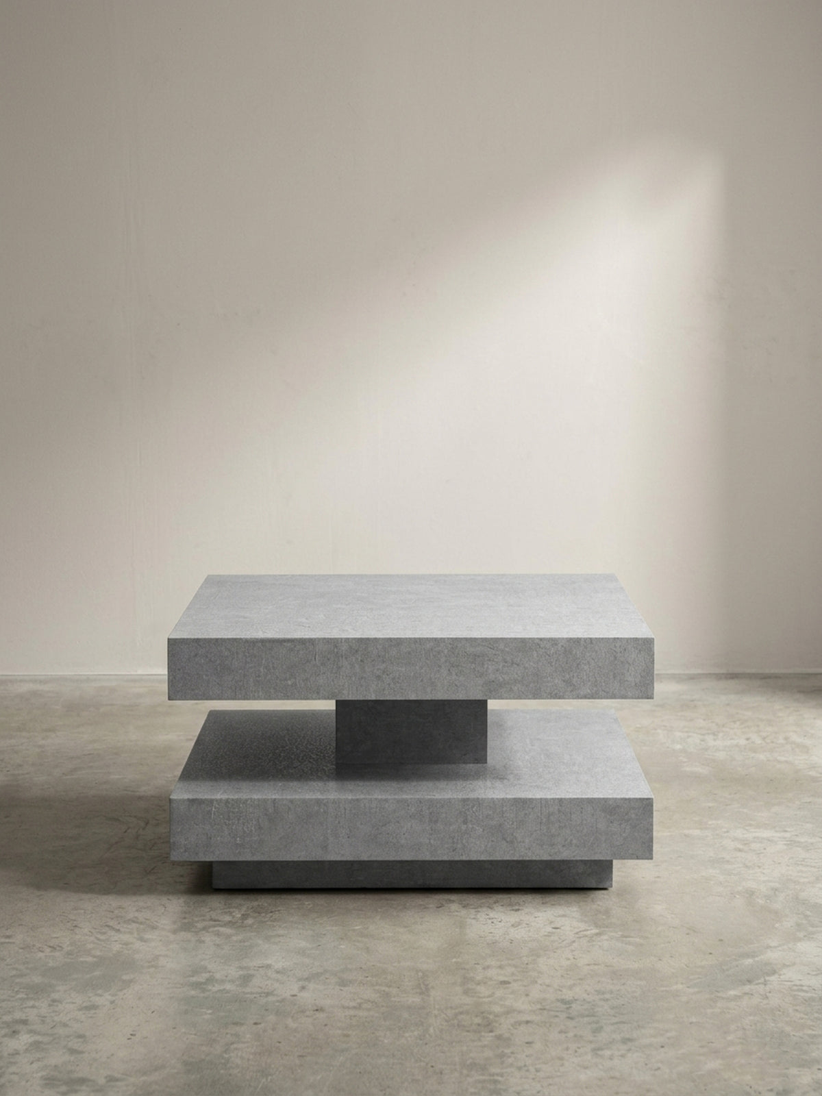 Schräge 3/4-Ansicht des modernen Sofatisches in Grau, die Tiefe und das geometrische Design der doppelten Ablagefläche betont._