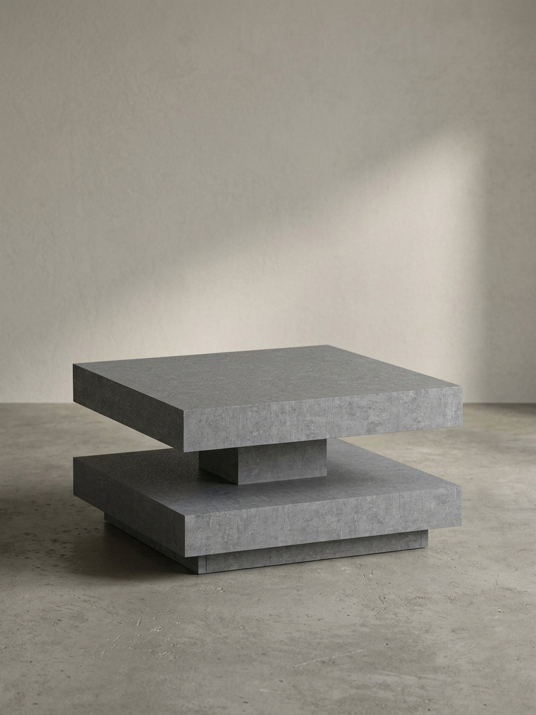 Frontansicht des quadratischen Couchtisches in Beton-Optik, der seine skulpturale, zweistufige Form auf weißem Hintergrund präsentiert._