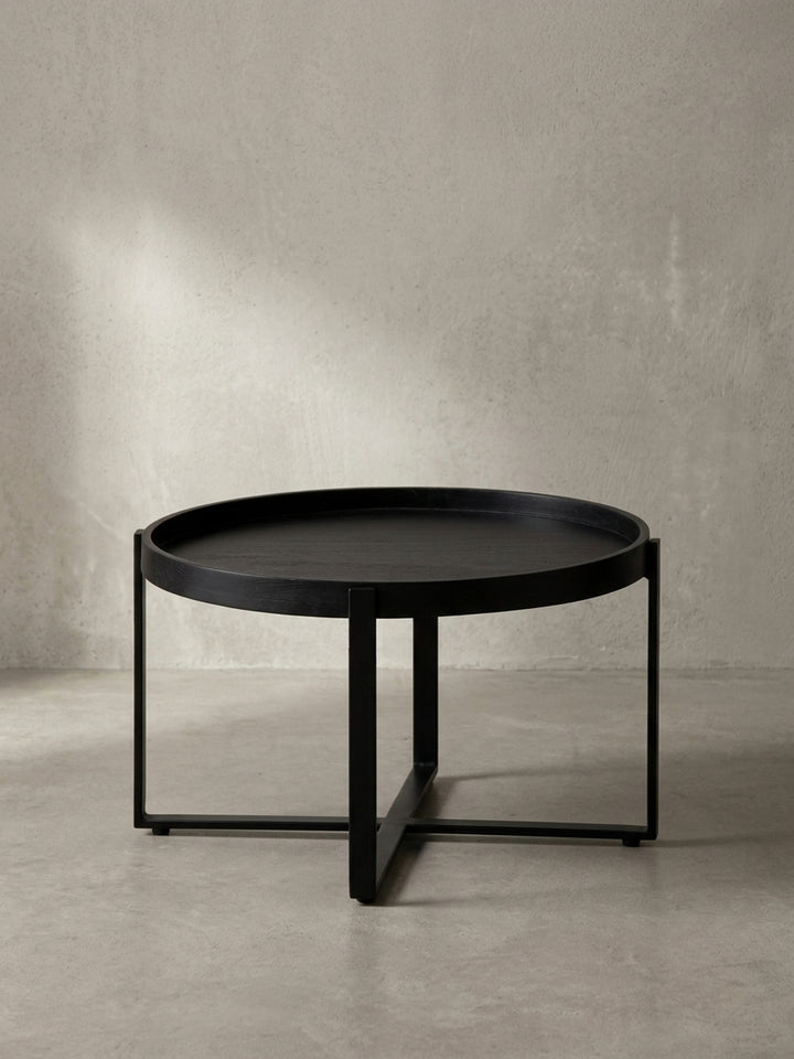 Seitenansicht des Design-Couchtisches, die seine niedrige Höhe von 35 cm und die schlanke Silhouette des schwarzen Eisengestells betont._