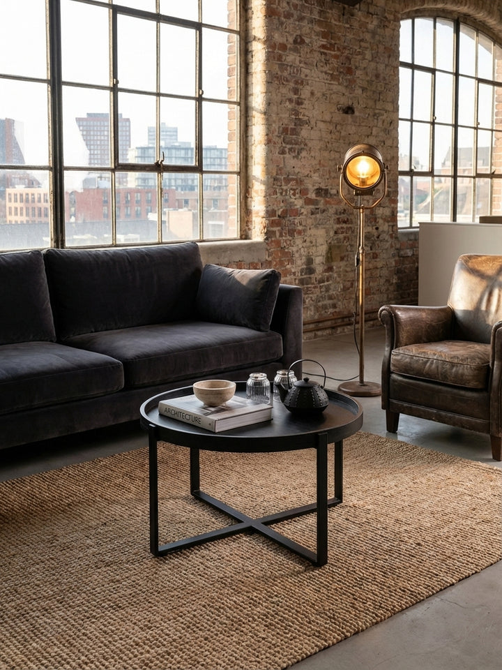 Der schwarze Industrial-Couchtisch kombiniert mit einem cremefarbenen Leinensofa, schafft einen stilvollen Kontrast im modernen Wohnambiente._