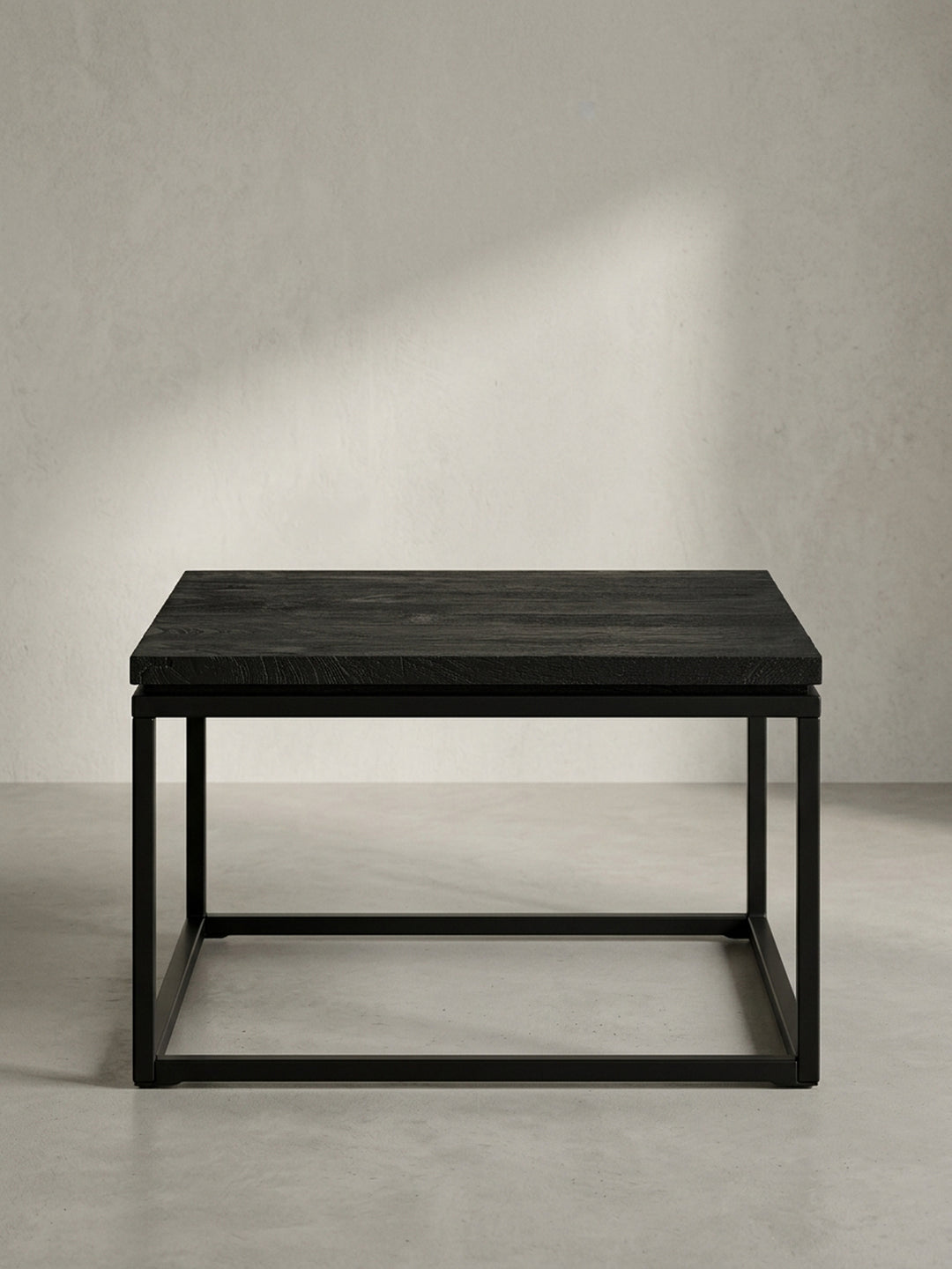 Seitenansicht des niedrigen Sofatisches, der die Proportionen mit 35 cm Höhe und das Zusammenspiel von massiver Holzplatte und offenem Metallrahmen zeigt._