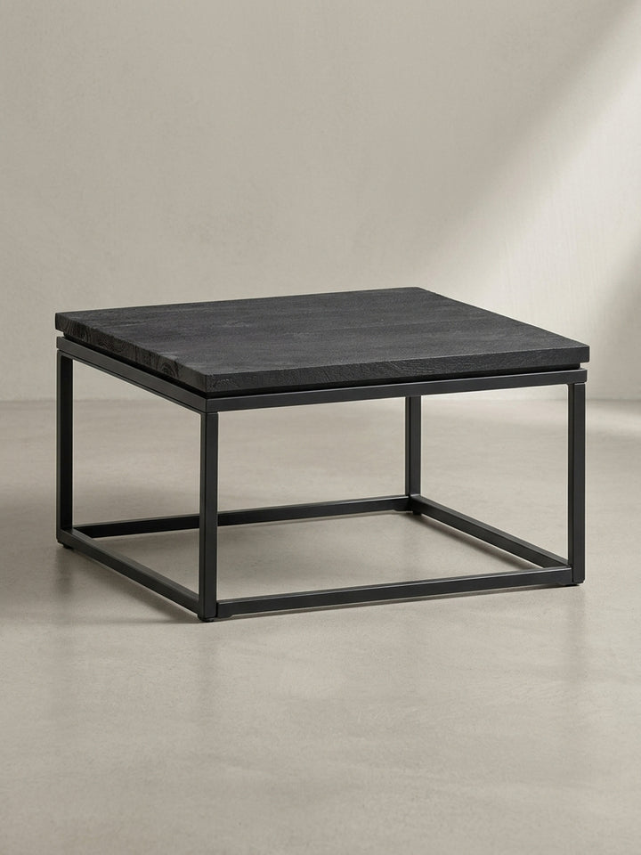 Überblick über den minimalistischen Couchtisch, der massive, texturierte Mangoholzplatte und ein geometrisches Eisengestell zu einem Unikat vereint._
