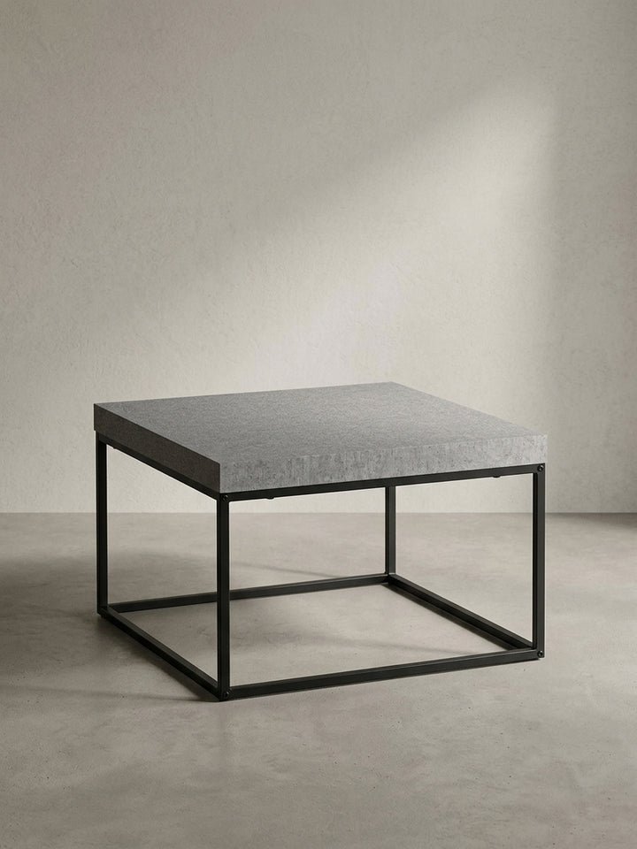 Der quadratische Couchtisch mit Metallbeinen als zentrales Element für ein modernes und industriell inspiriertes Wohnambiente._