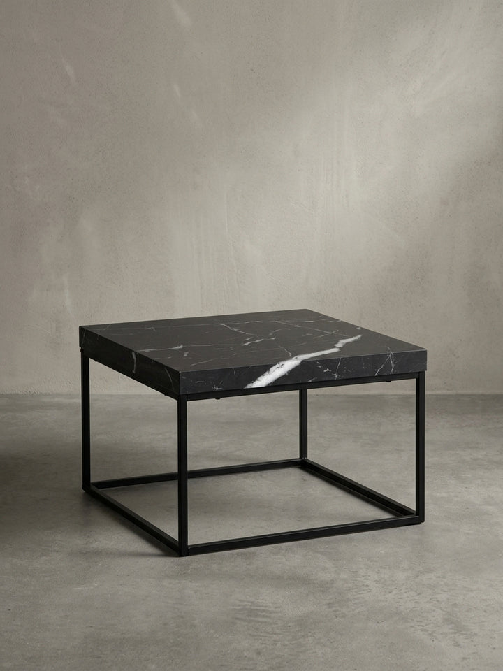 Sofatisch aus beschichtetem Holzwerkstoff und Metall in Schwarz von schräg oben betrachtet, zeigt die markante 5 cm dicke kubische Tischplatte._