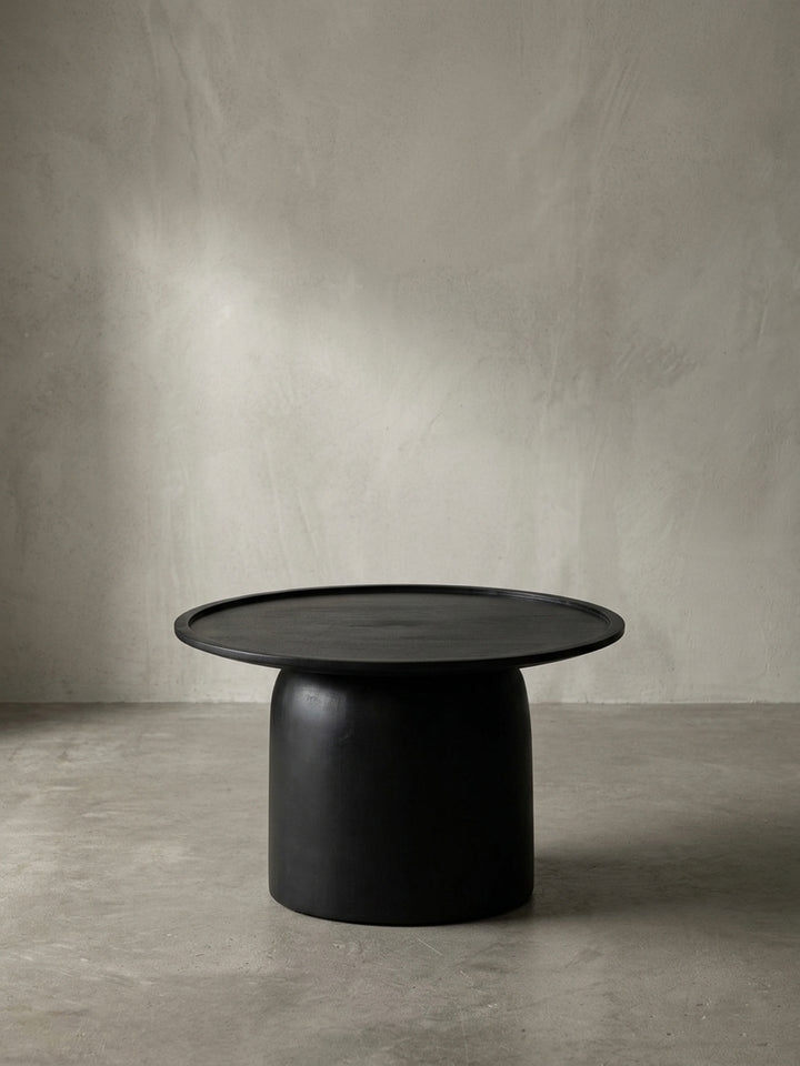 Gesamtansicht des massiven, schwarzen Couchtisches, der sein zeitloses und minimalistisches Design aus Mangoholz präsentiert._