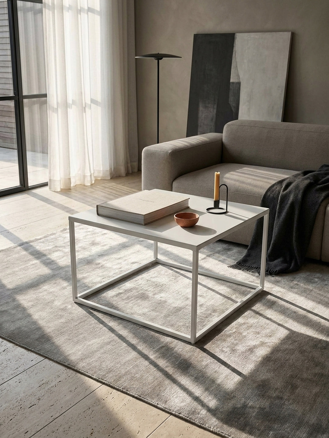 Detailansicht der mattweißen Lackierung des quadratischen Couchtischs aus Stahl mit präzise verschweißten Eckverbindungen und feiner Haptik_