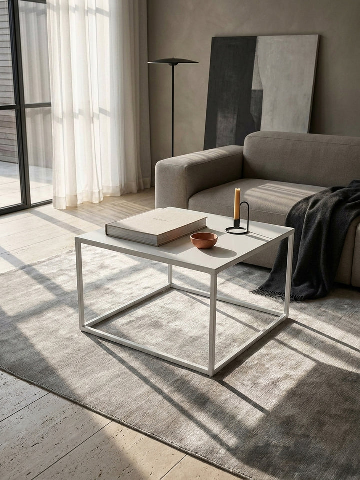 Detailansicht der mattweißen Lackierung des quadratischen Couchtischs aus Stahl mit präzise verschweißten Eckverbindungen und feiner Haptik_