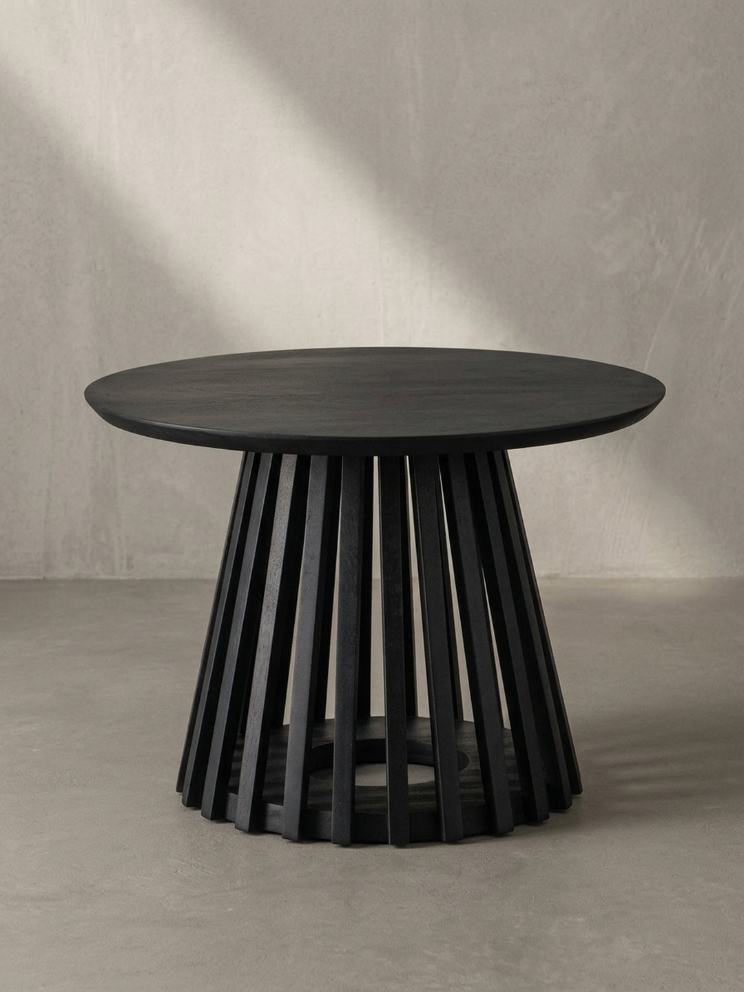 Nahaufnahme des Gittergestells, das die saubere Verarbeitung der einzelnen Holzlatten des schwarz lackierten Couchtisches demonstriert._